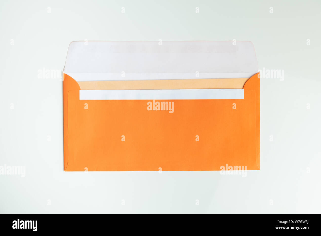 Orange envelope in white background, top view. Abstract image of postal