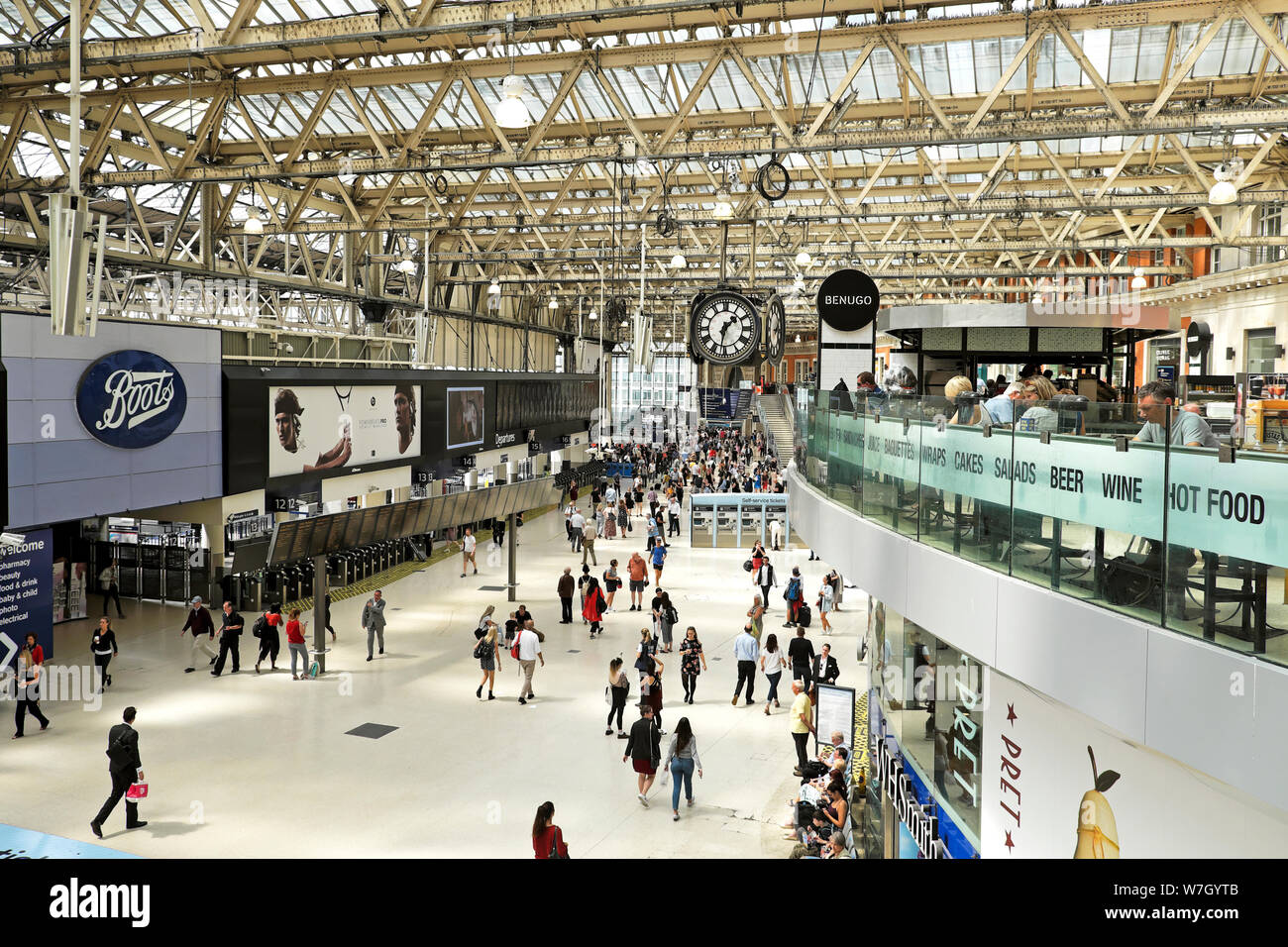 People eating at Benugo restaurant and shoppers walking past shops on the concourse at Waterloo Station in London England UK  KATHY DEWITT Stock Photo