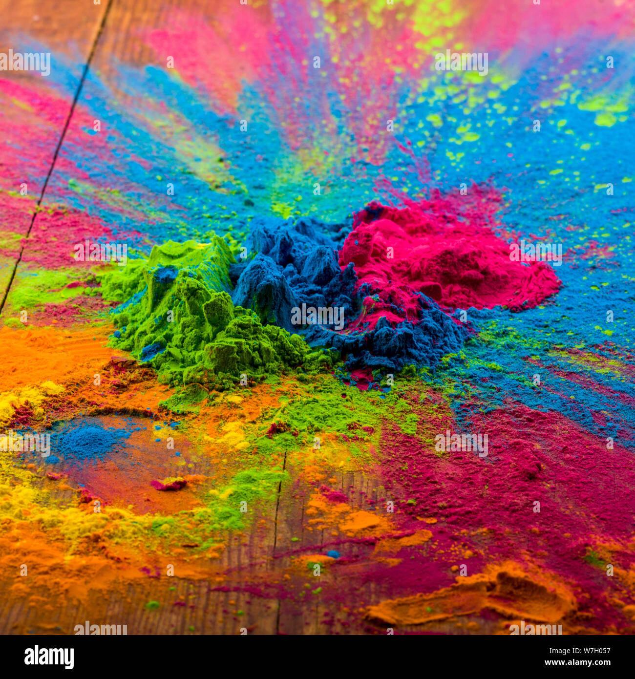 Abstract colorful Happy Holi background. Color vibrant powder on wood. Dust colored splash texture. Flat lay holi paint decoration. Stock Photo
