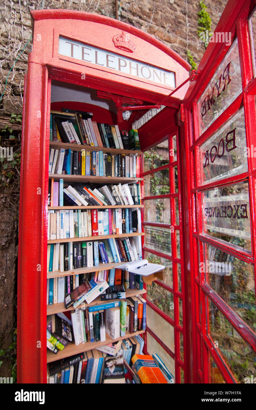 A traditional red BT British Telephone Kiosk adopted as a community library in Ryme Intrinsica in North West Dorset near Yeovil in Somerset Stock Photo
