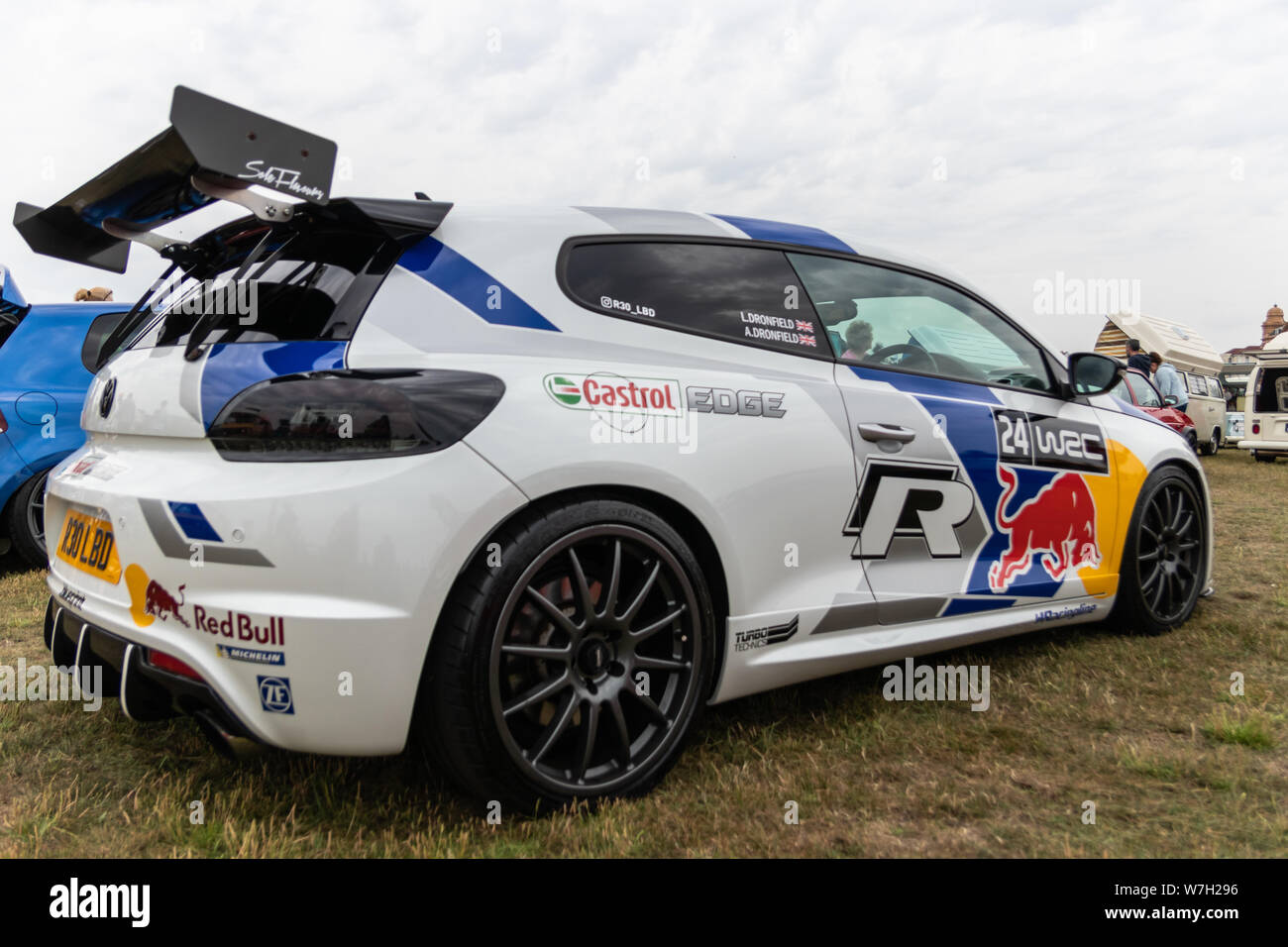A Volkswagen or VW racing car at a car show decorated with sponsors names Stock Photo