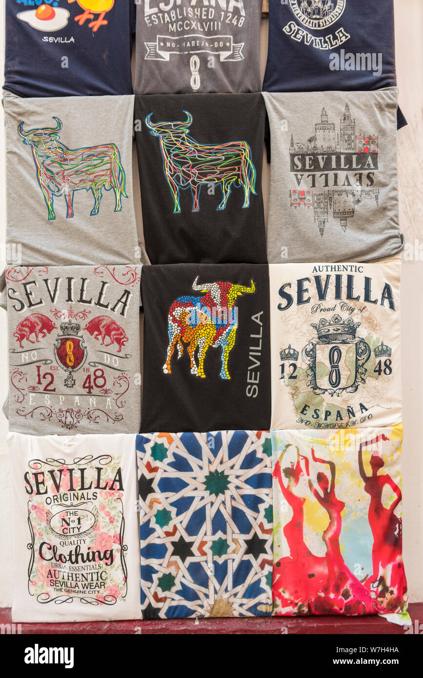 A display of T shirts with various images of Seville on them for sale as souvenirs in a tou=rist gift shop in Seville Spain. Stock Photo