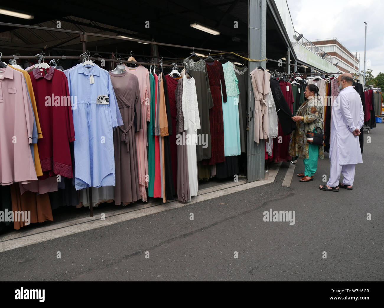 Shopping for Asian women's fashion and material on an outdoor market in Bolton, Lancashire, Greater Manchester, England UK, .  photo DON TONGE Stock Photo