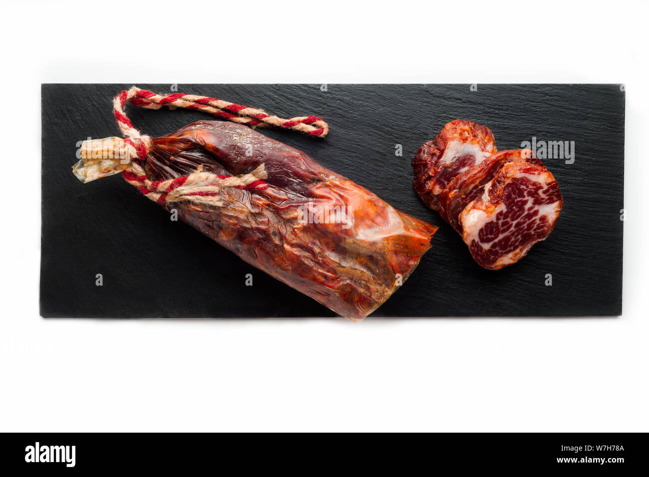 black tray of delicious Iberian pork loin on white background Stock Photo
