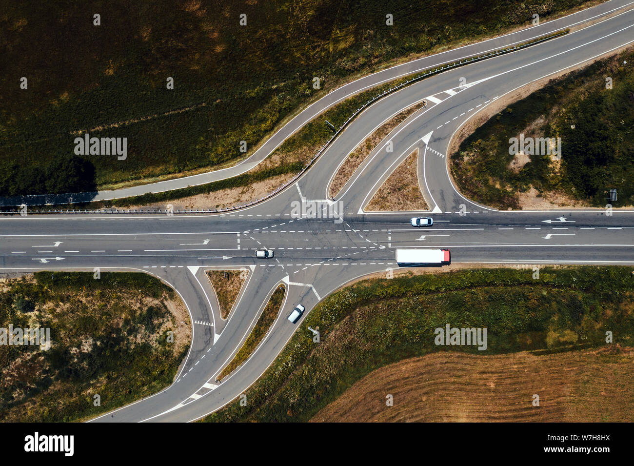 Aerial view of traffic on road intersection with turning lines from drone pov directly above Stock Photo