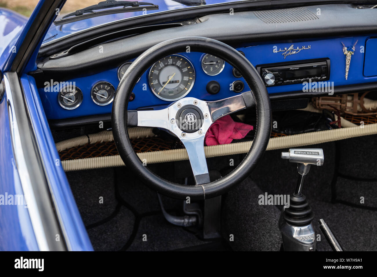 the interior of a vintage car showing the steering wheel and dashboard plus speedometer Stock Photo