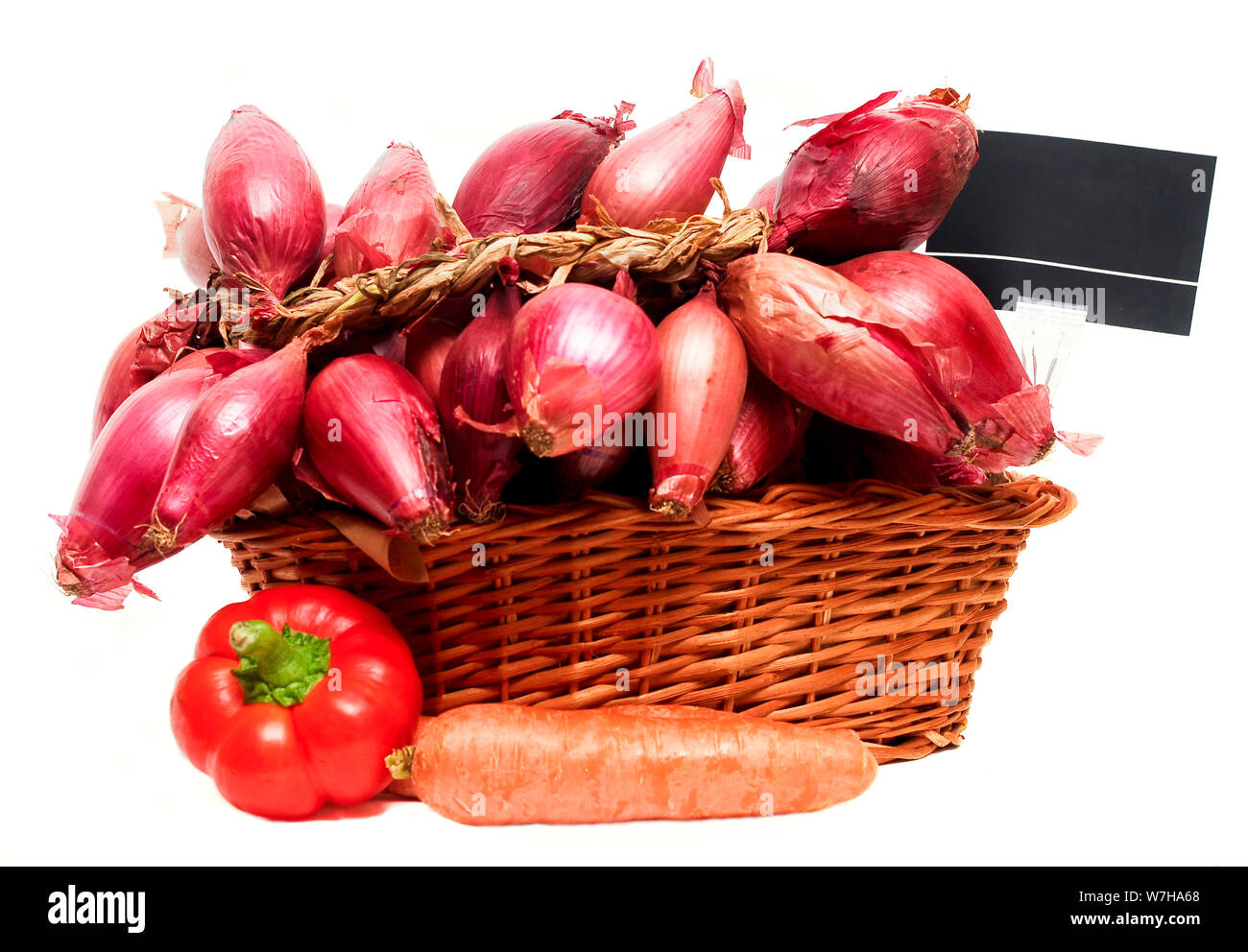 Basket full of red onions and price tag, isolated on white background. Stock Photo