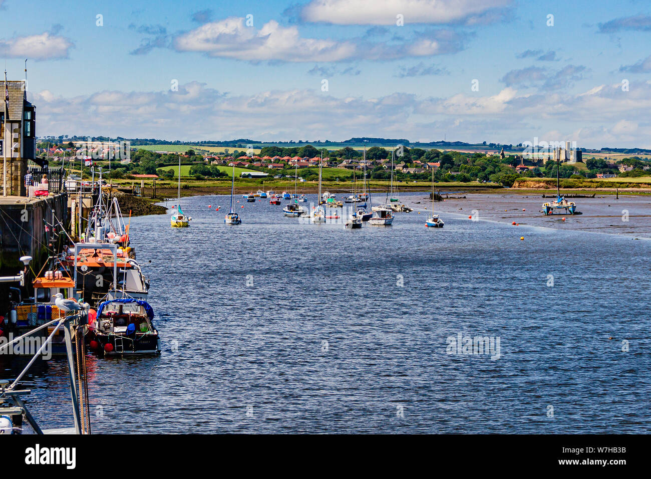A view over the tidal Coquet Estuary at Amble towards Warkworth village and castle, Northumberland, UK. July 2019. Stock Photo