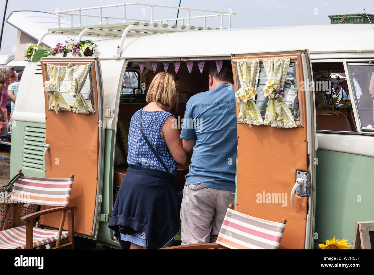 A middle aged couple looking into a Volkswagen camper van Stock Photo