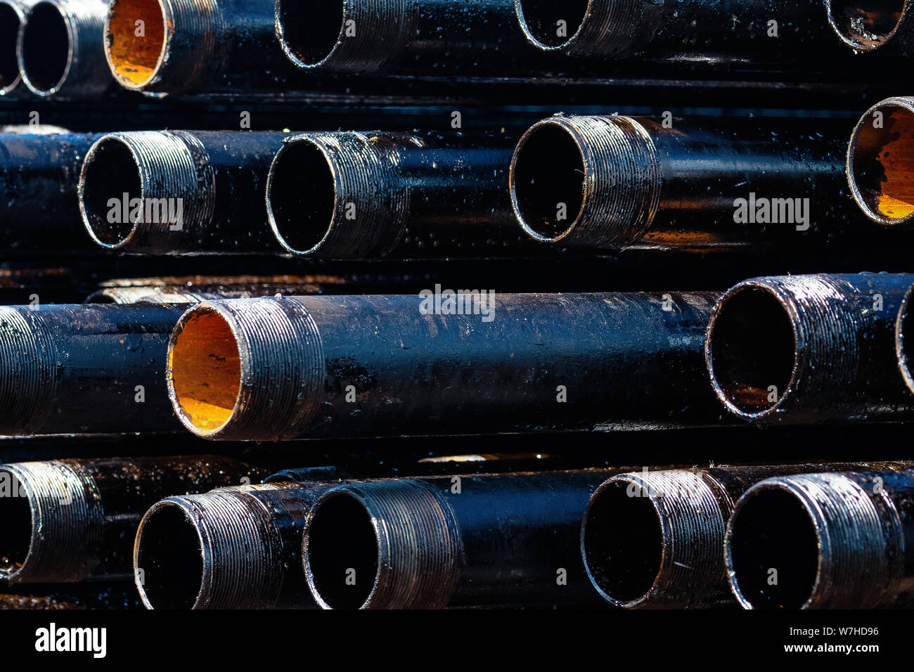 View of drilling pipes casing and tubing stacked at open yard of oil