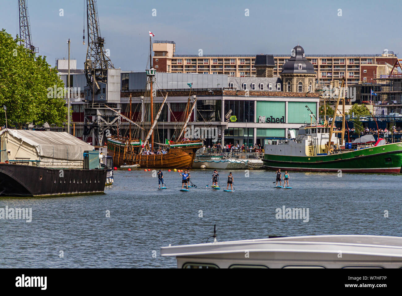 A group of paddle boarders enjoying the Floating Harbour near the M-Shed heritage museum on Prince's Wharf, Bristol, UK. July 2019. Stock Photo