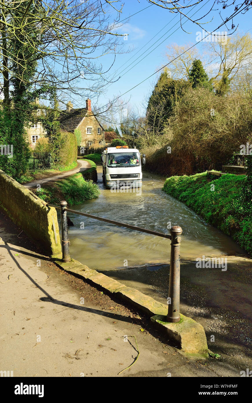 Refuse collection vehicle negotiating Bide Brook ford in Lacock, Wiltshire. Stock Photo