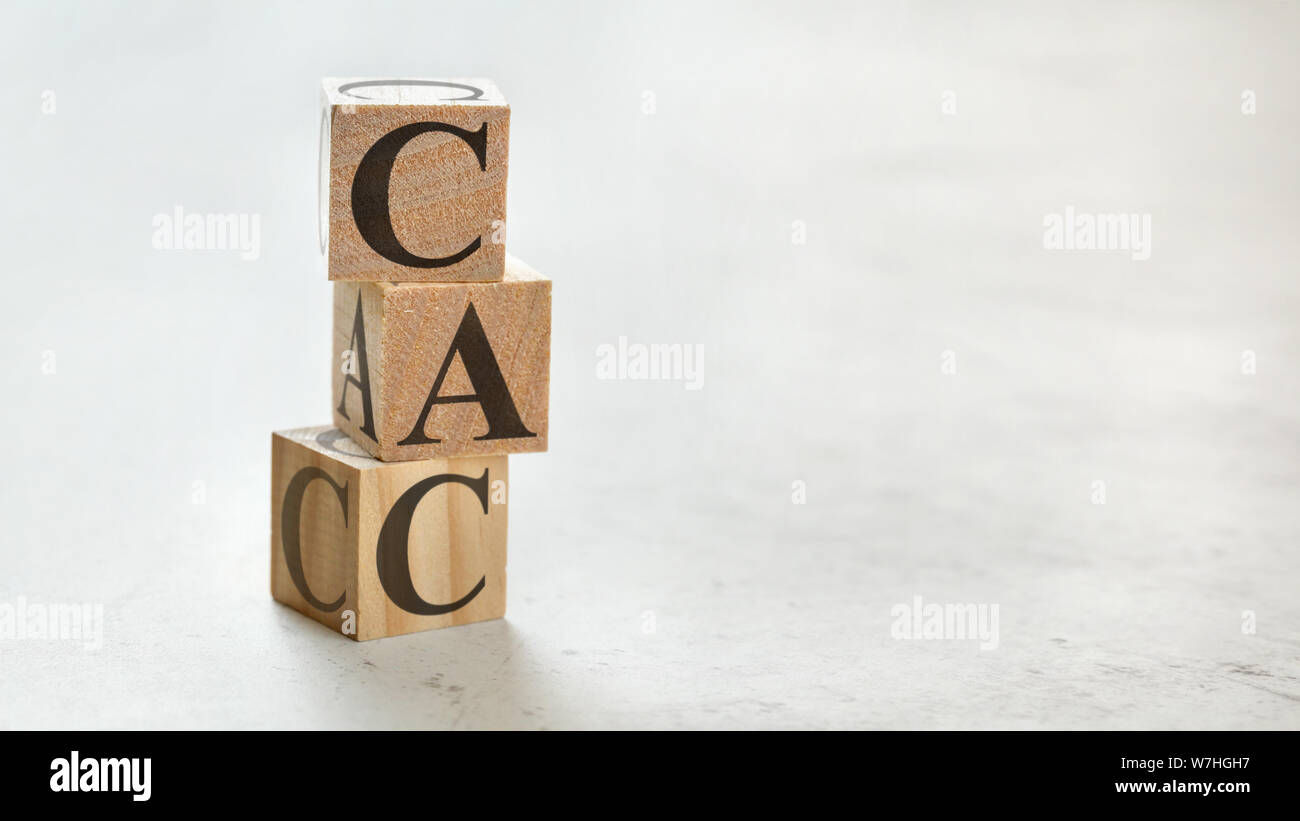 Pile with three wooden cubes - letters CAC meaning Customer Acquisition Cost on them, space for more text / images at right side. Stock Photo