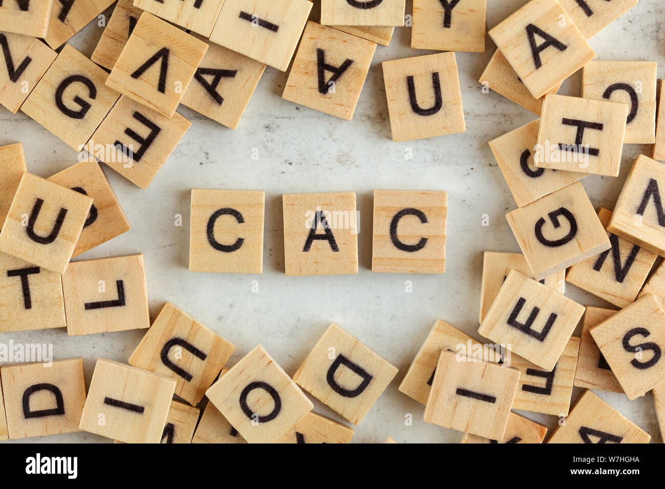 Top down view, pile of square wooden blocks with letters CAC (stands for Customer acquisition cost) on white board. Stock Photo