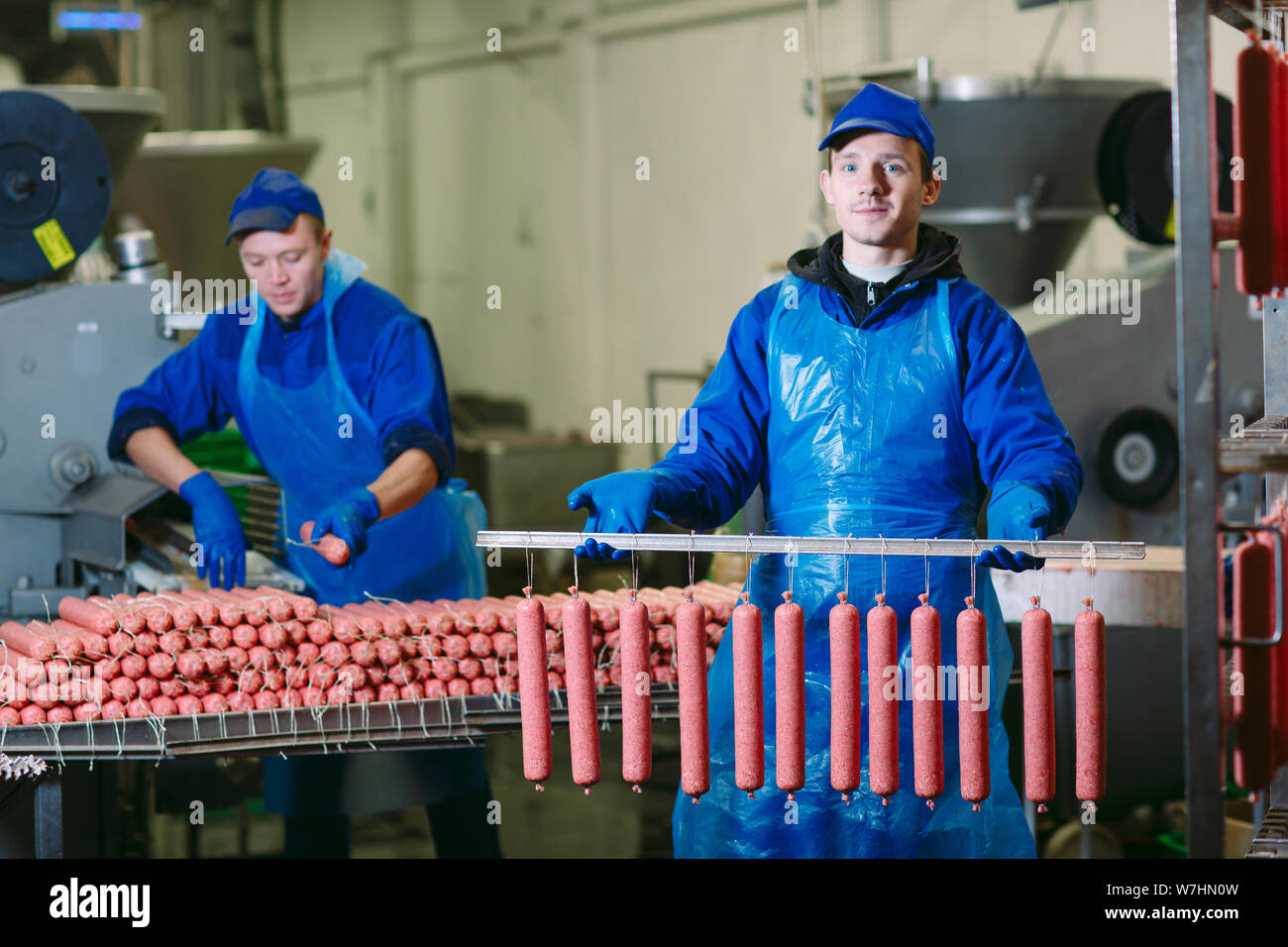 Portrait of butchers processing sausages at meat factory Stock Photo Alamy