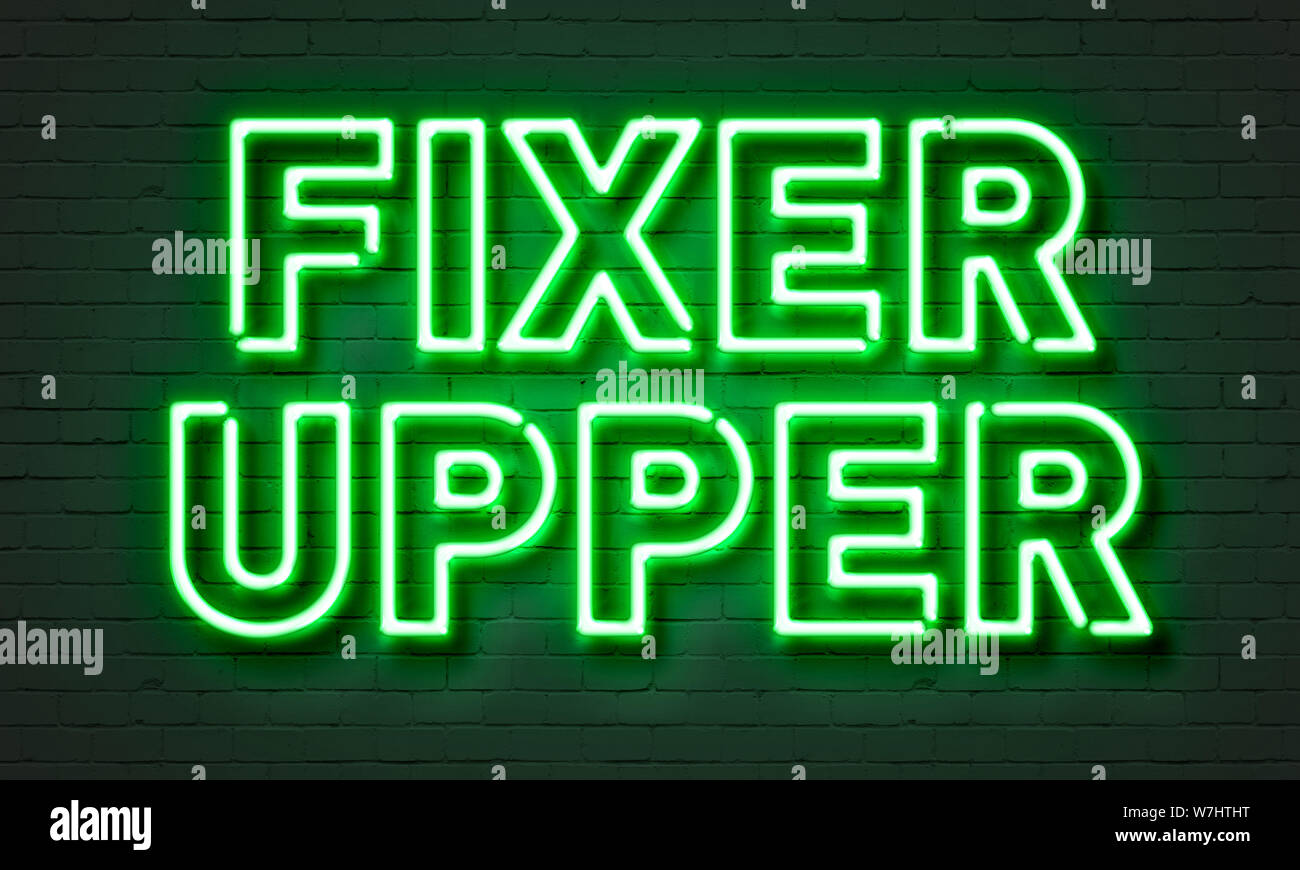 Fixer upper neon sign on brick wall background Stock Photo