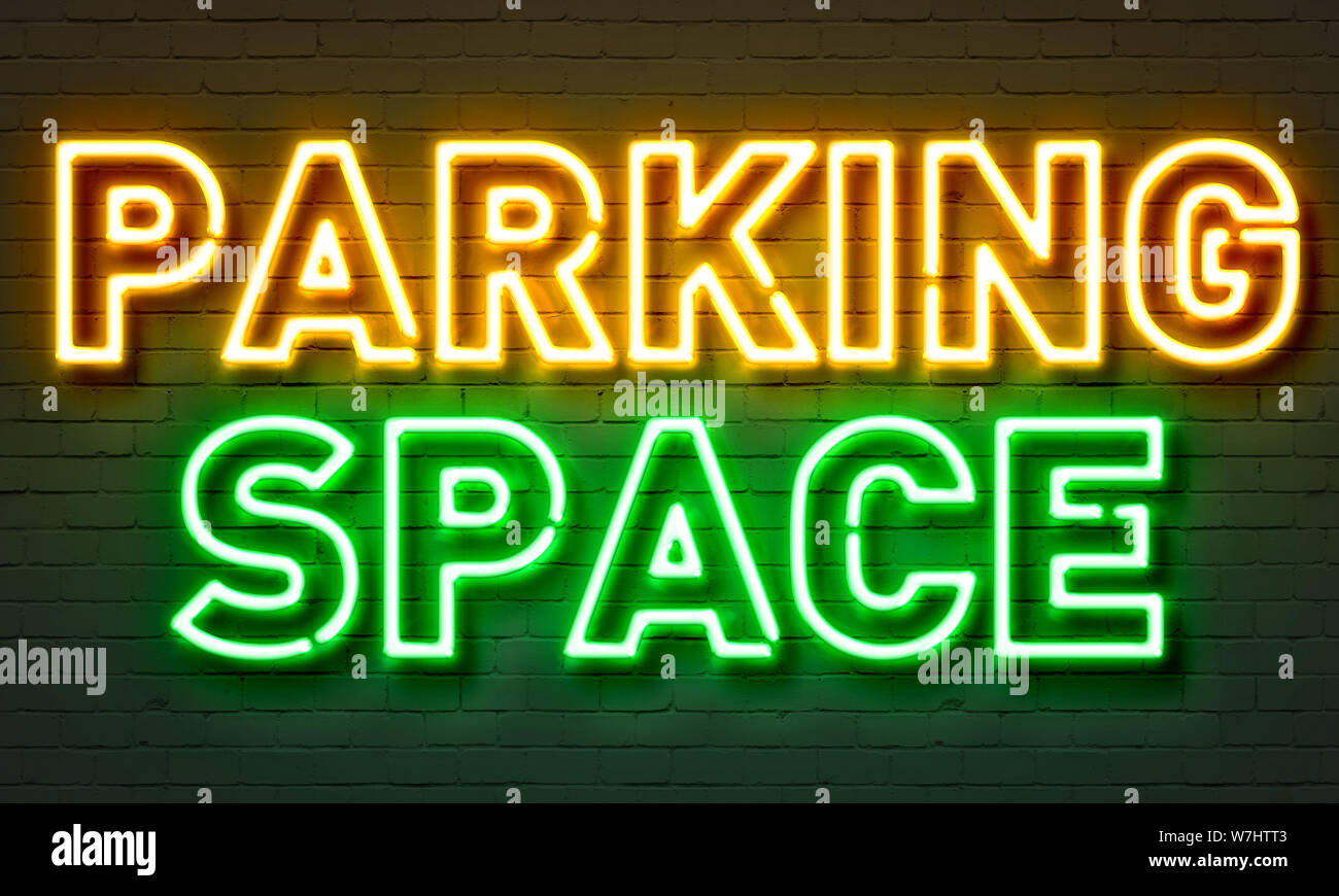 Parking space neon sign on brick wall background Stock Photo