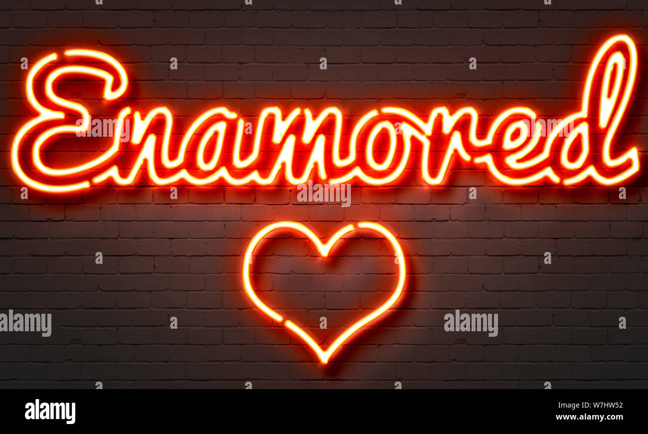 Enamored neon sign on brick wall background Stock Photo