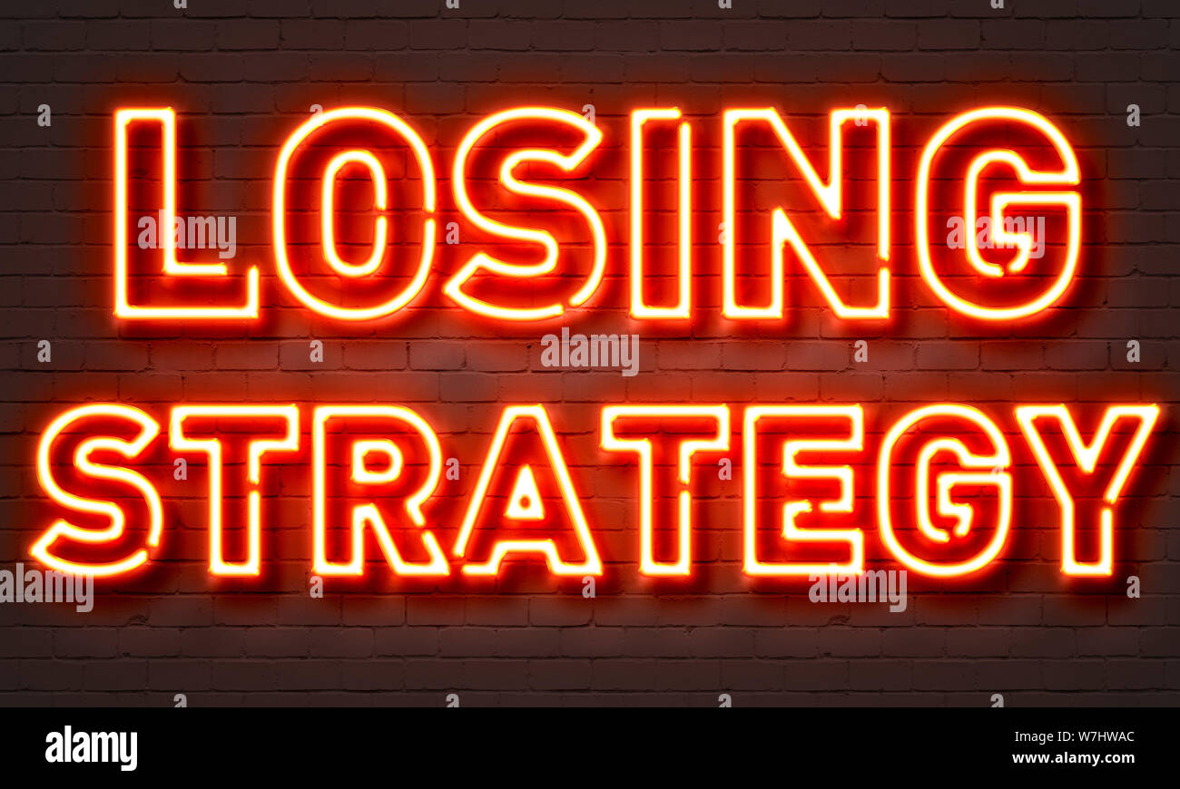 Losing strategy neon sign on brick wall background Stock Photo