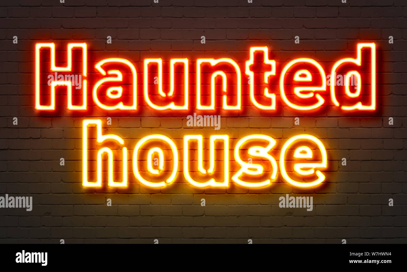 Haunted house neon sign on brick wall background Stock Photo