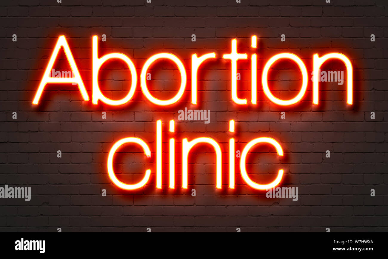 Abortion clinic neon sign on brick wall background Stock Photo