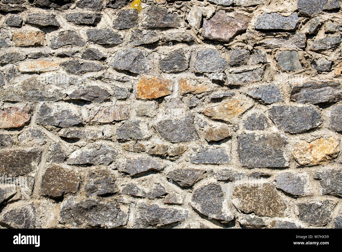 Old stone wall. Granite Wall Surface Stock Photo
