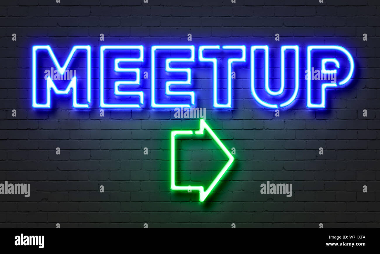Meetup neon sign on brick wall background Stock Photo