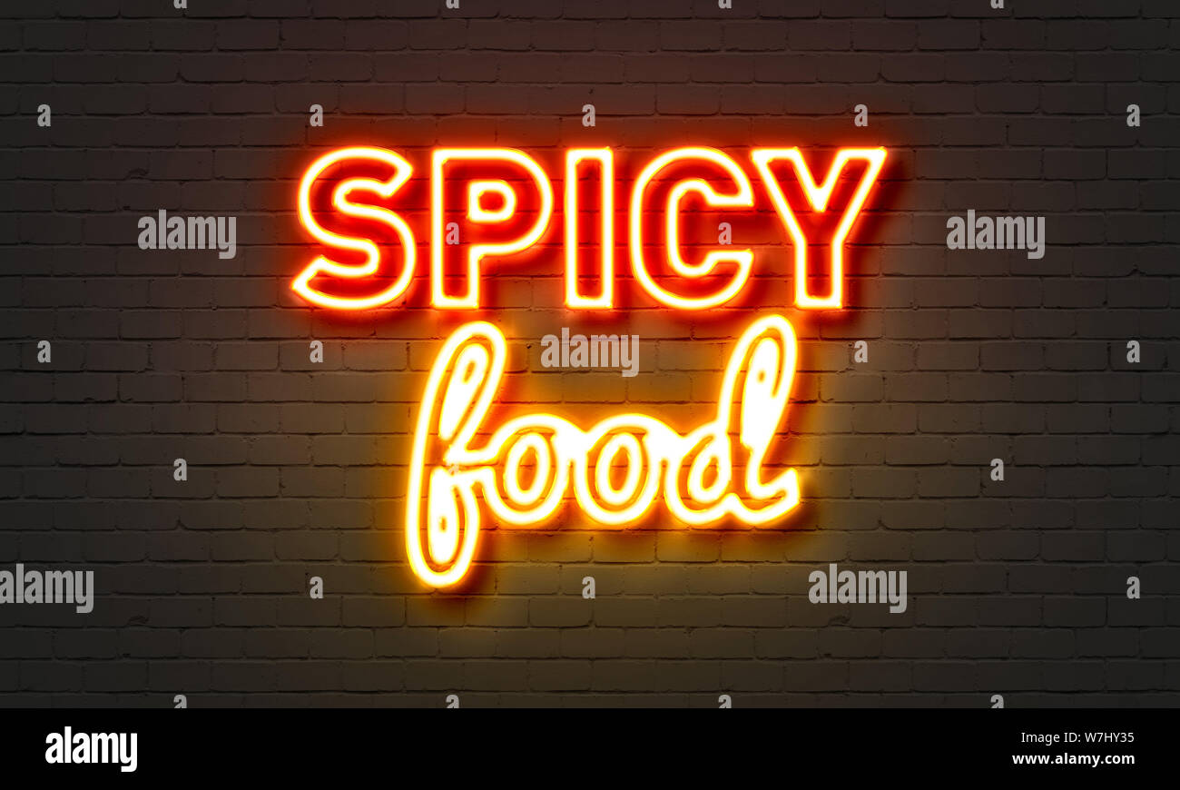 Spicy food neon sign on brick wall background Stock Photo