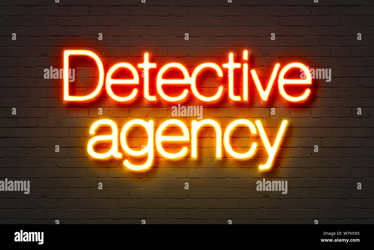 Detective agency neon sign on brick wall background Stock Photo