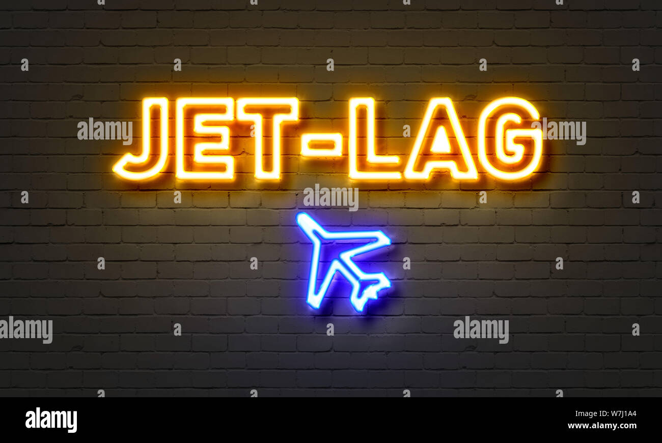 Jet-lag neon sign on brick wall background Stock Photo