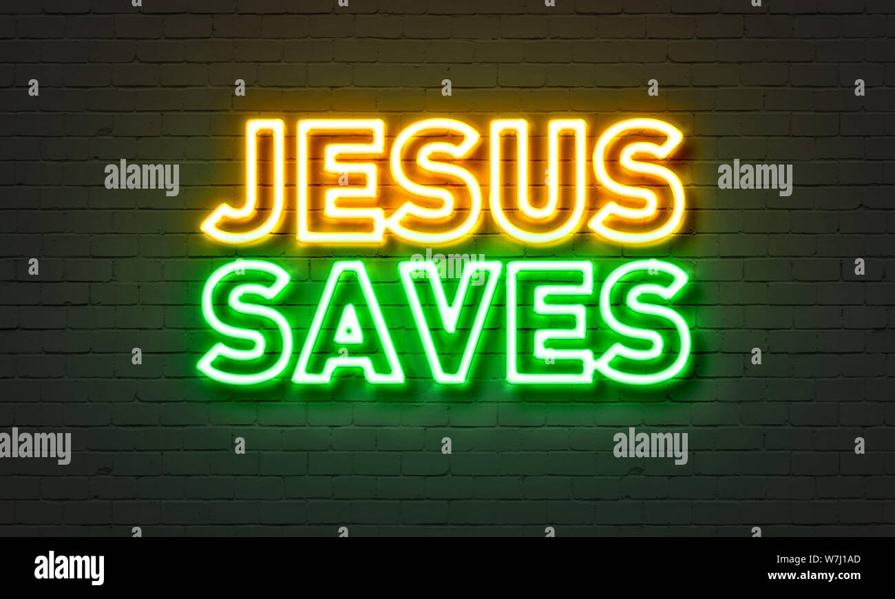 Jesus saves neon sign on brick wall background Stock Photo