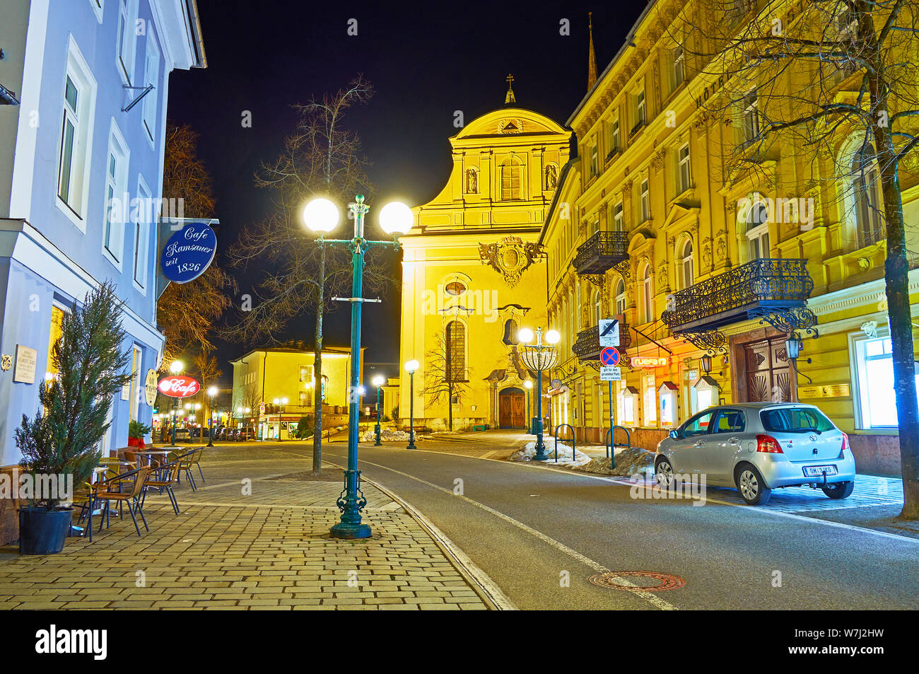 BAD ISCHL, AUSTRIA - FEBRUARY 20, 2019: Evening Franz Joseph Strasse with a view on illuminated St Nicholas Parish Church and classical buildings, on Stock Photo