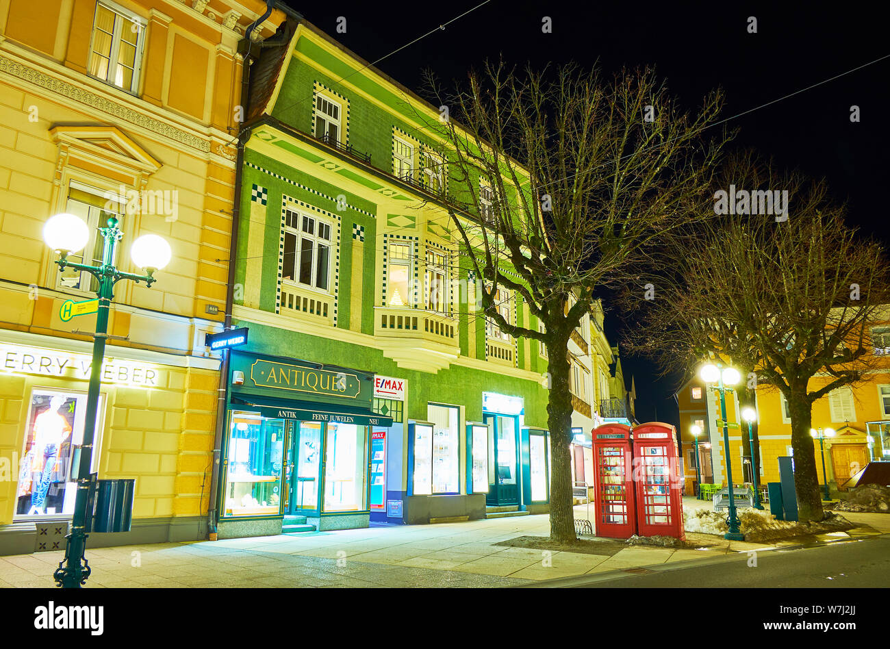 BAD ISCHL, AUSTRIA - FEBRUARY 26, 2019: The scenic illuminated townhouses in Kreuzplatz square with stores, restaurants, art galleries and antique sho Stock Photo