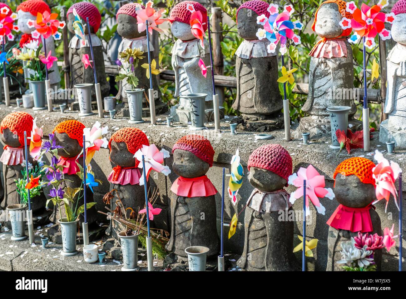 Jizo statues with red caps, protective deities for deceased children, Unborn Children Garden. Zojoji Temple, Buddhist Temple, Tokyo, Japan Stock Photo