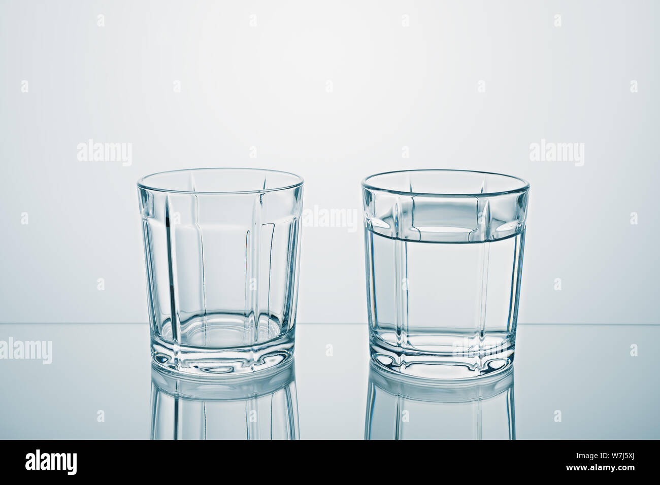 Inspirere pouch Lære Two glasses one empty, one full of clean water Stock Photo - Alamy