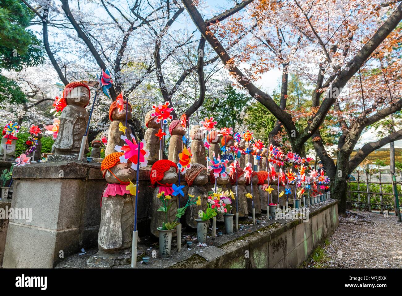 Jizo statues with red caps, protective deities for deceased children, Unborn Children Garden. Zojoji Temple, Buddhist Temple, Tokyo, Japan Stock Photo