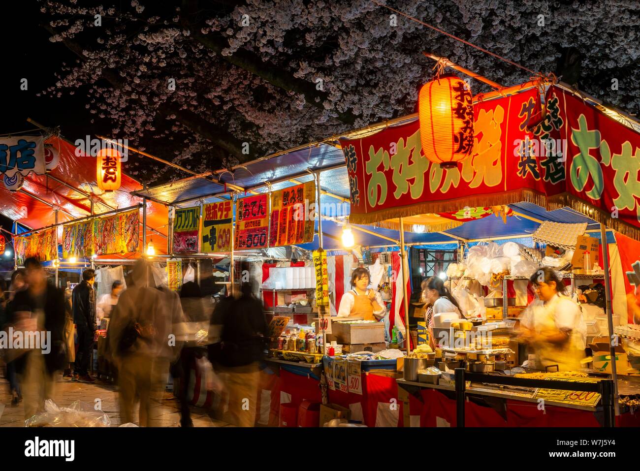 Food stalls with Japanese food at night, cherry blossom in spring, Hanami Fest, Ueno Park, Taito City, Tokyo, Japan Stock Photo