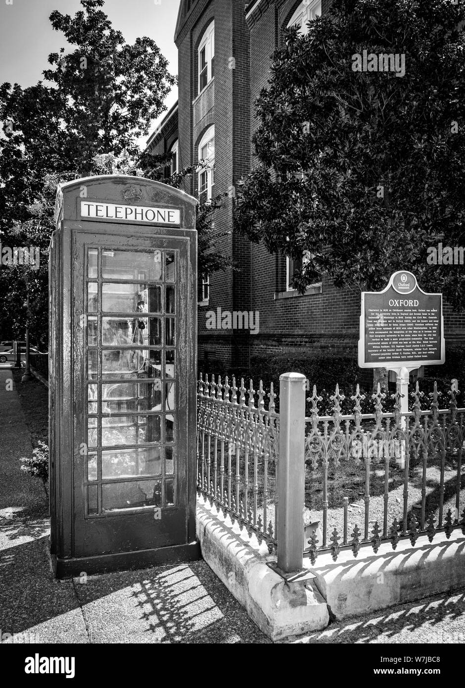 The iconic British red telephone box on the Courthouse Square alongside Oxford City Hall, with historic Oxford marker, Mississippi, MS, B & W Stock Photo