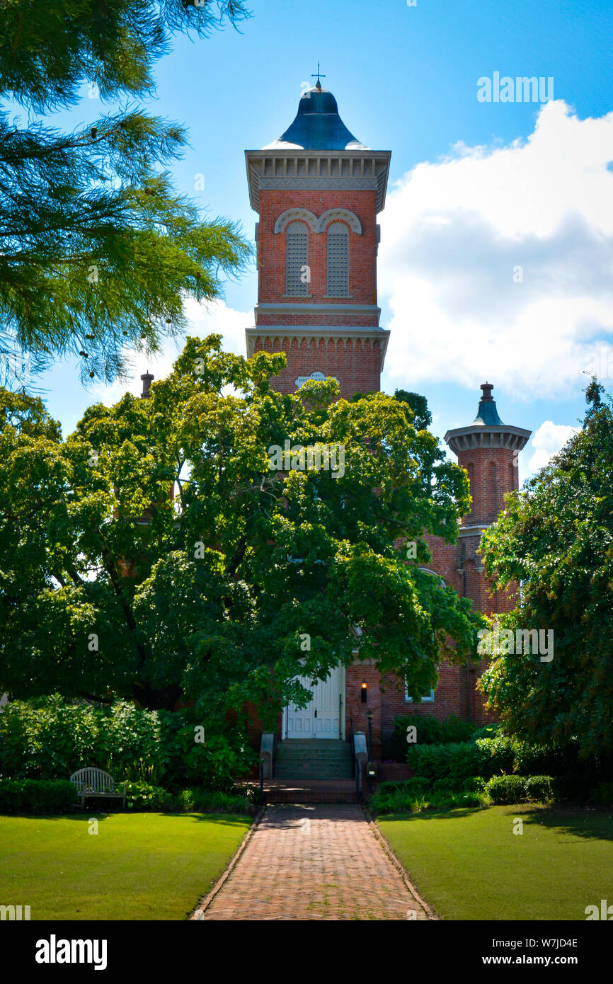 Red brick pathway towards the door to the Romanesque Revival design of the First Presbyterian Church, shrouded by Linden trees, founded in 1937, in Ox Stock Photo