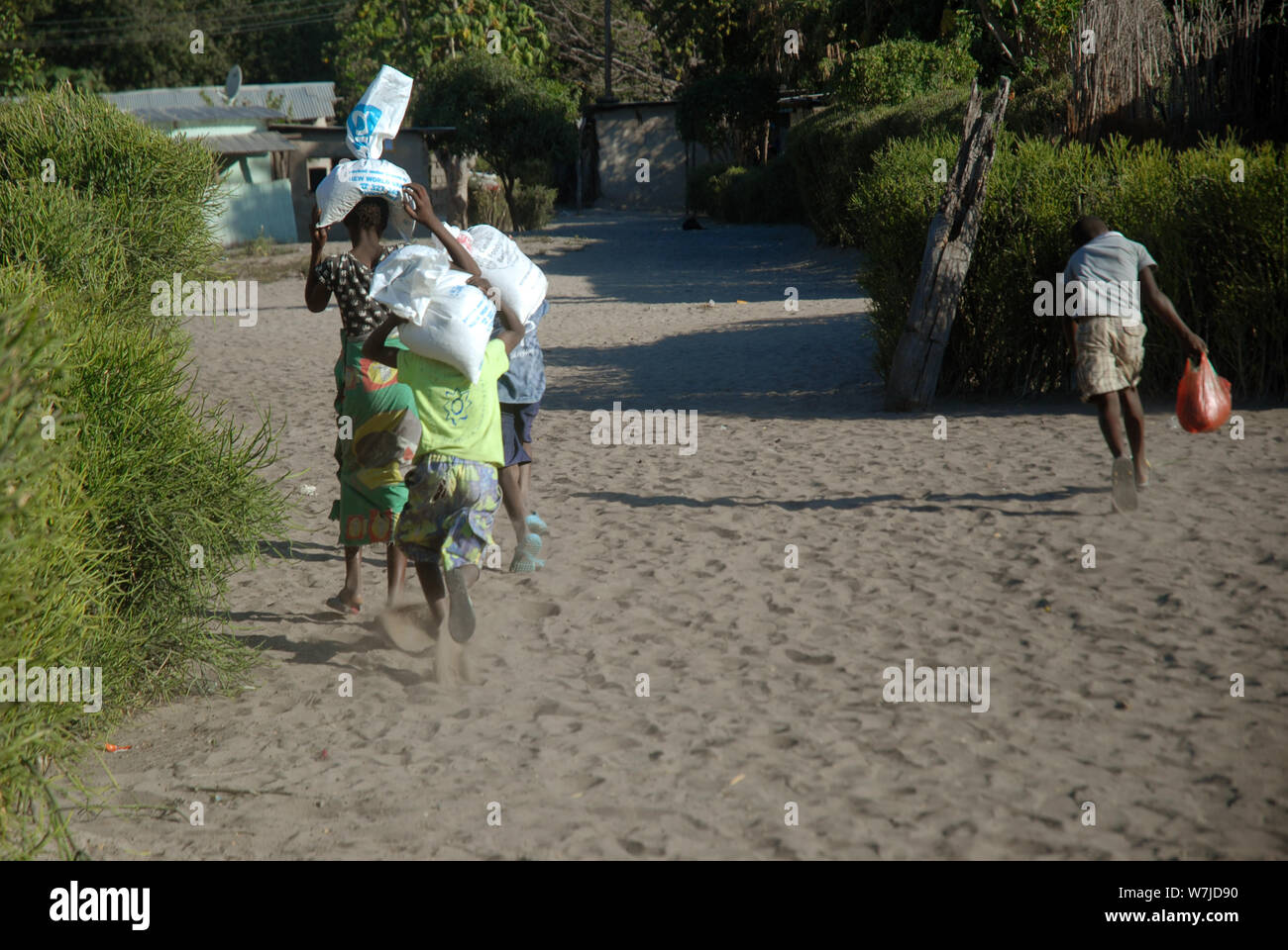 Children carrying Bags of maize on their heads, Mwandi, Zambia, Africa