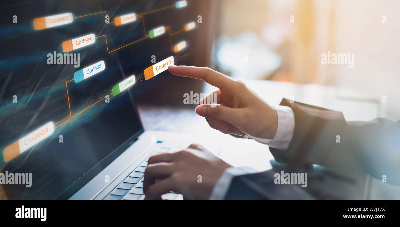 Businessman pointing icon code label coherent and application development screen on the laptop computer. coding technology design. Stock Photo