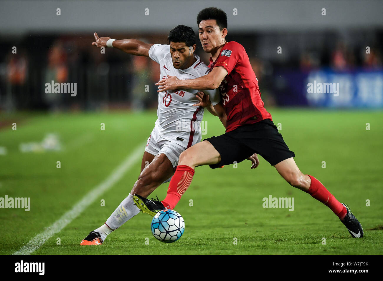 Li Xuepeng of China's Guangzhou Evergrande Taobao, right, challenges ...