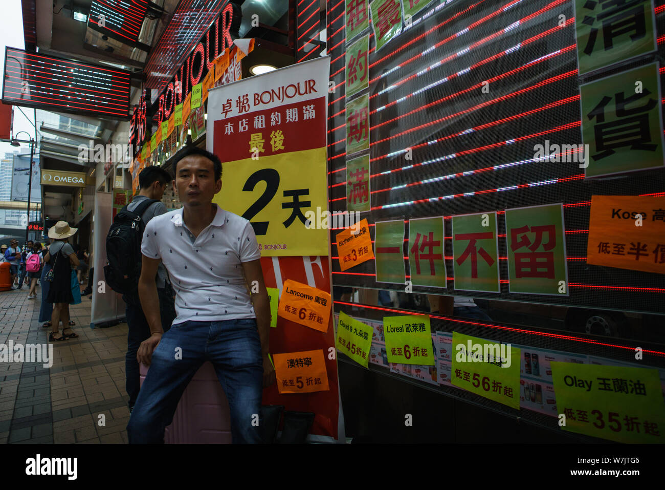 A mainland Chinese man sits on his suitcase in the retail district of Tsim Sha Tsui in Hong Kong, China, 3 September2017.   Hong Kong is on the verge Stock Photo