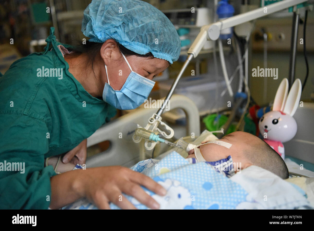 The mother Xie Huiyan takes care of her six-year-old daughter Jin Jin diagnosed with brainstem encephalitis, who has been in coma and lived on a respi Stock Photo