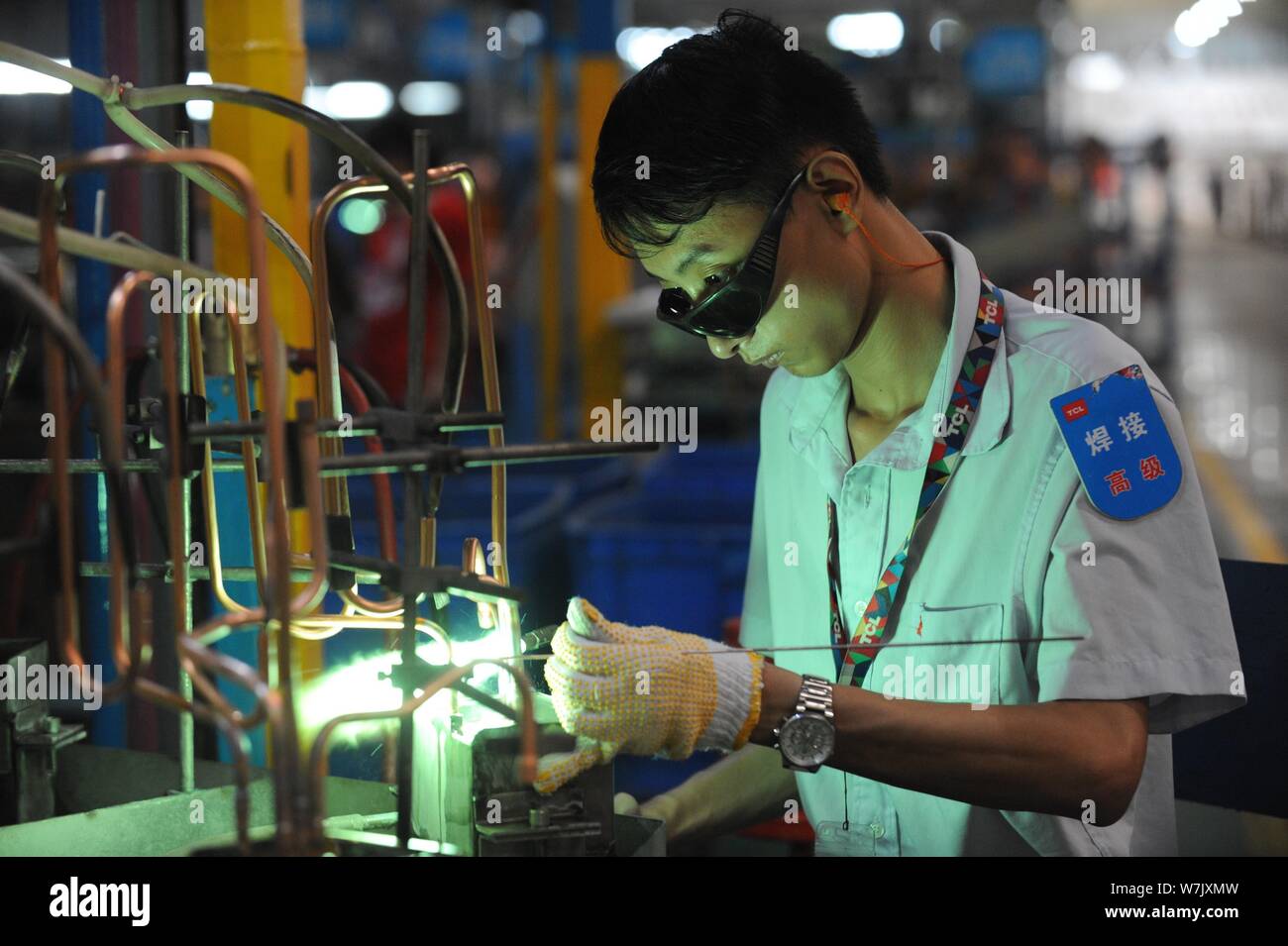 --FILE--A Chinese worker welds parts for air-conditioners on the assembly line at a plant of TCL in Wuhan city, central China's Hubei province, 26 Jul Stock Photo