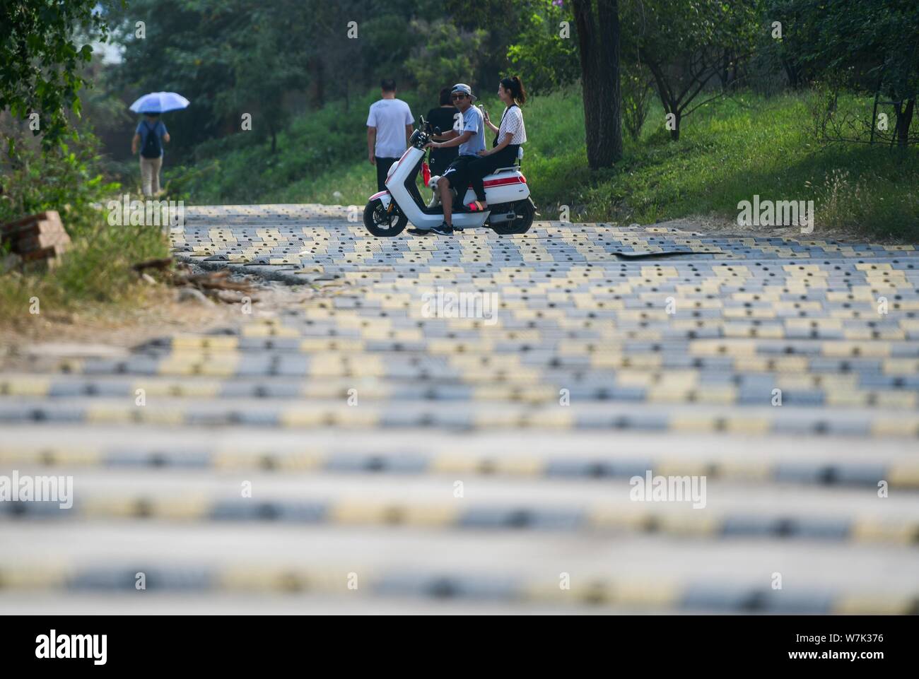 A cyclist rides on a 200meterlong "washboard road" with more than 100 speed bumps in Fengtai