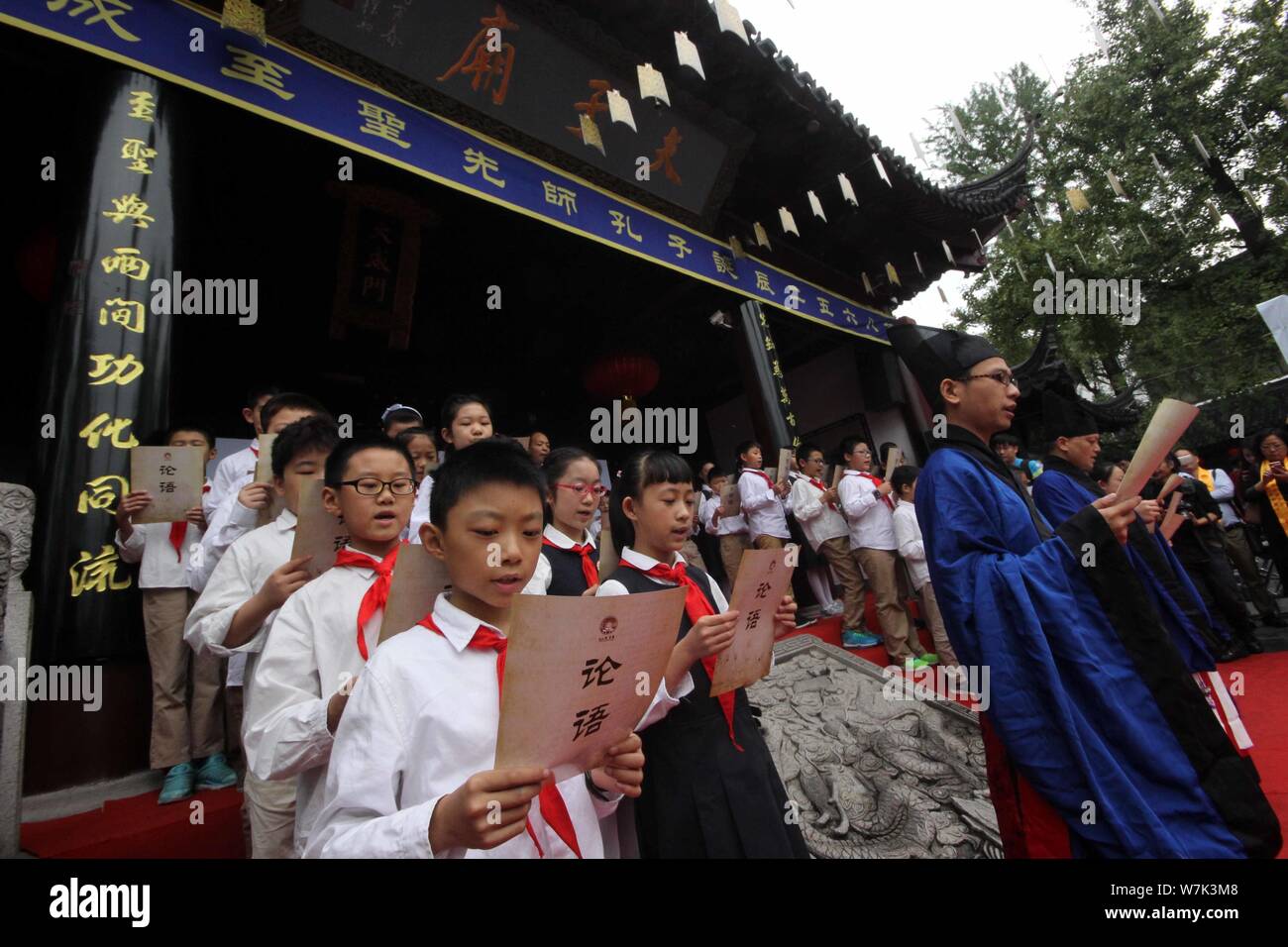 Young students read aloud the Analects of Confucius during a ritual to mark the 2,568th anniversary of the birth of the great Chinese philosopher Conf Stock Photo