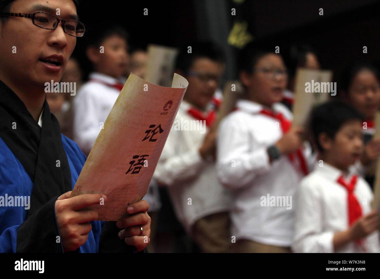 Young students read aloud the Analects of Confucius during a ritual to mark the 2,568th anniversary of the birth of the great Chinese philosopher Conf Stock Photo