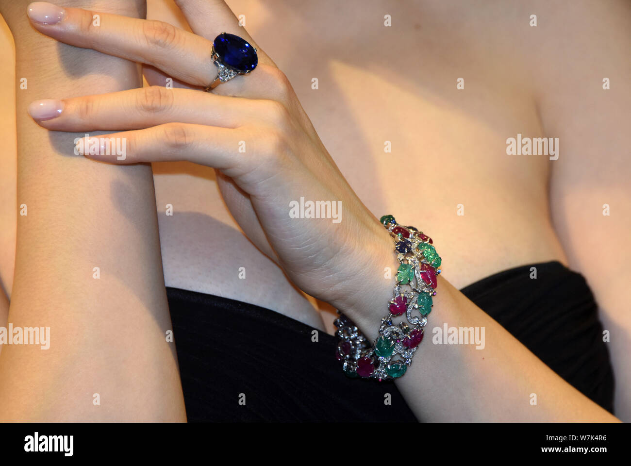 A model displays a Cartier Art Deco gem-set and diamond 'Tutti Frutti' bracelet and a sapphire and diamond ring by Bulgari during a preview for the Ma Stock Photo