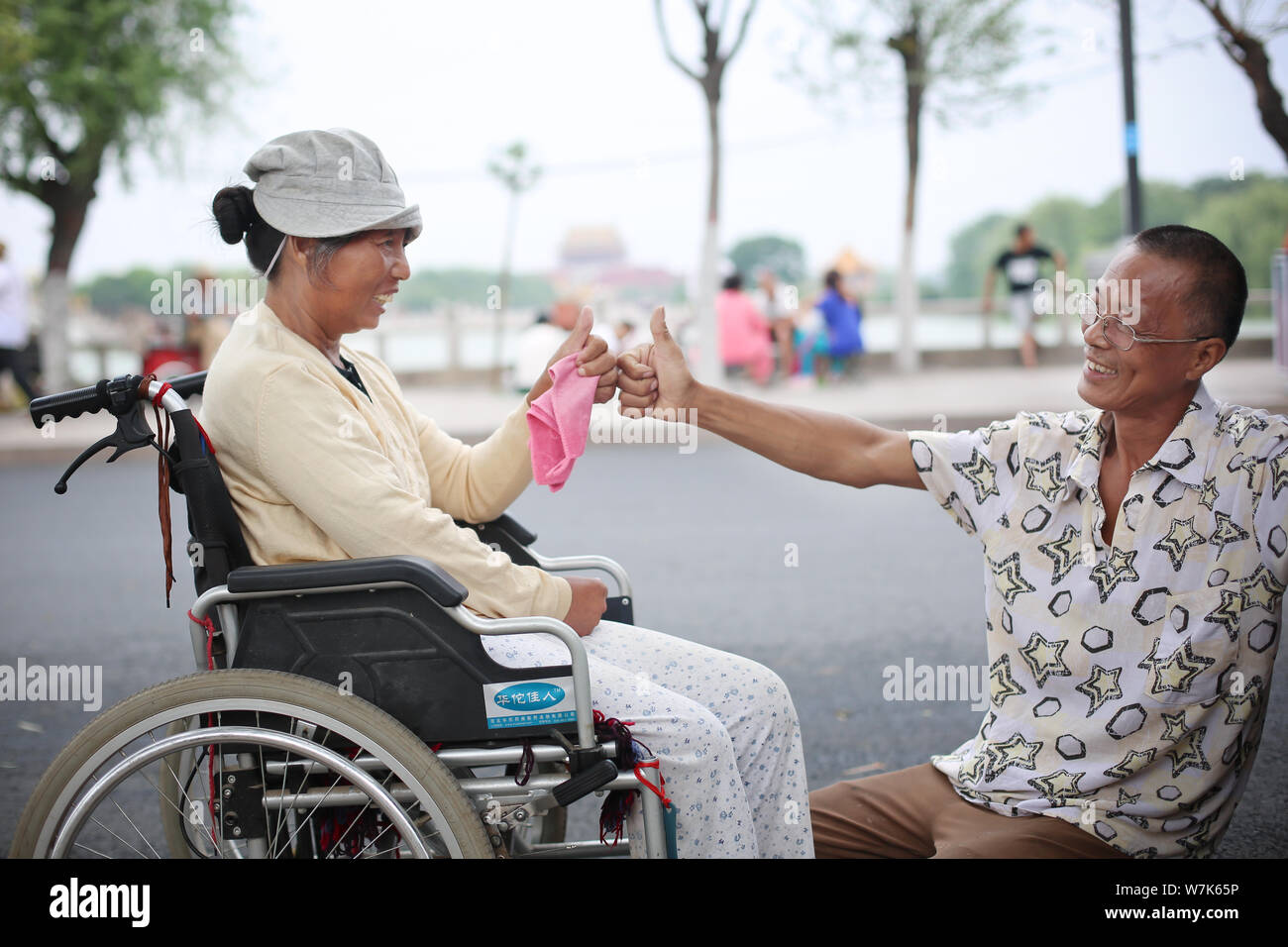 Chinese man Guo Jingxin interacts with his paralyzed wife in Zhengzhou city, central China's Henan province, 25 August 2017.   A Chinese man has turne Stock Photo